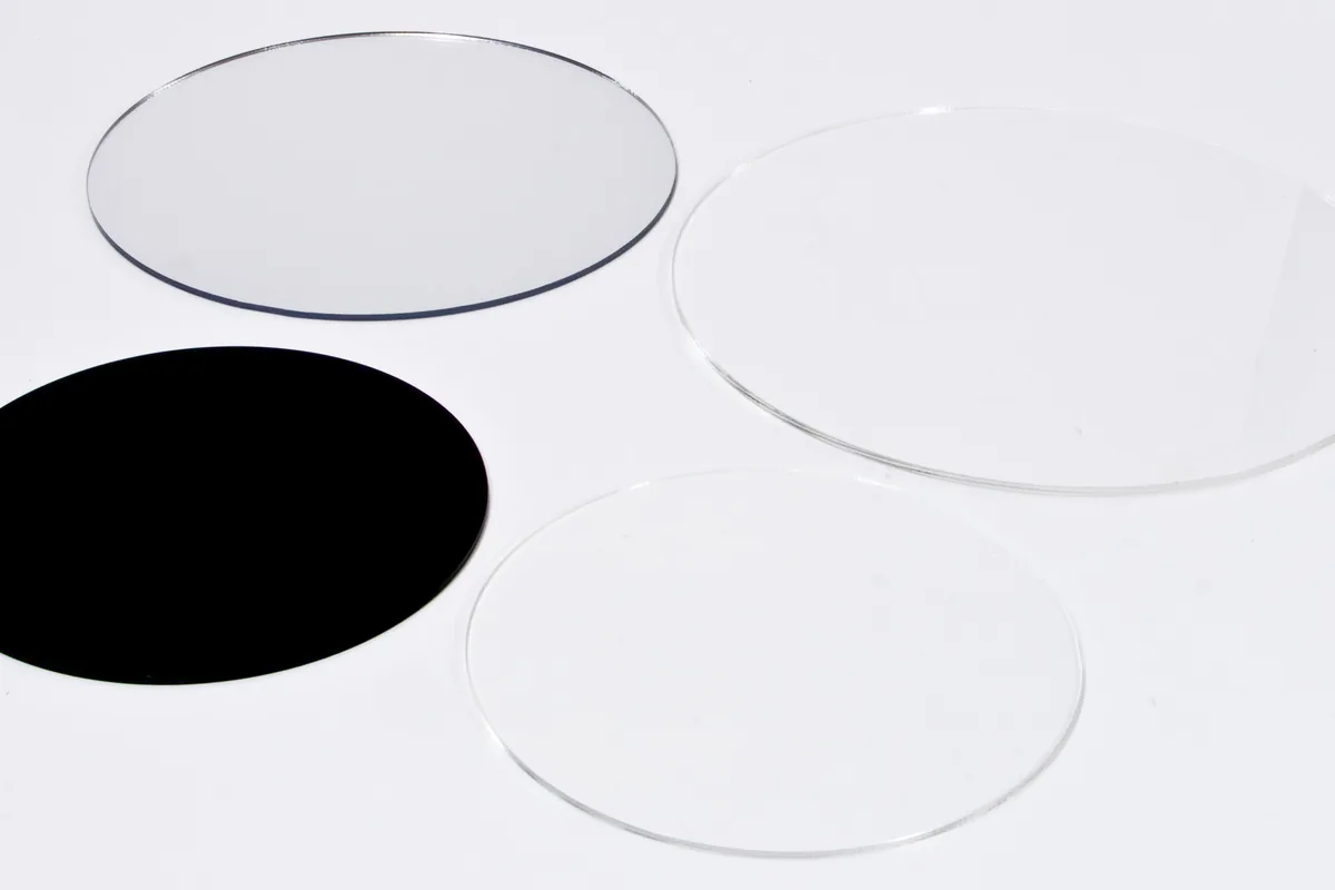 Vier runde Acrylzuschnitte: transparent, verspiegelt und schwarz