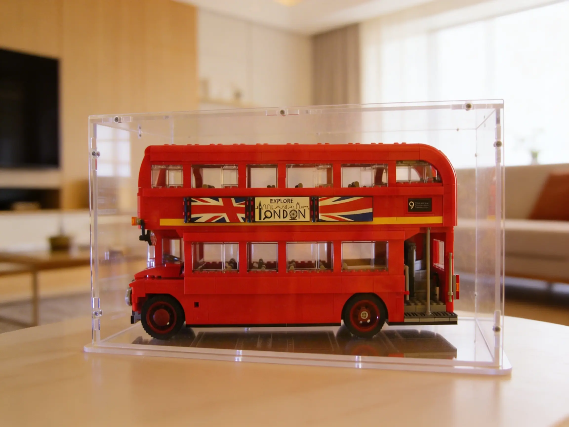 Sora-Acrylhaube über Lego Creator London Doppeldecker-Bus mit Union-Jack-Werbetafel auf Holztisch